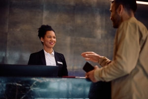 Concierge Employee Talking to Happy Customer at Her Desk
