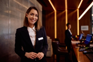 Happy Female Concierge Employee at Reception