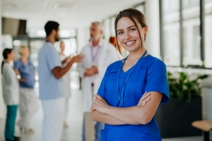 Smiling Young Nurse at Hospital Corridor