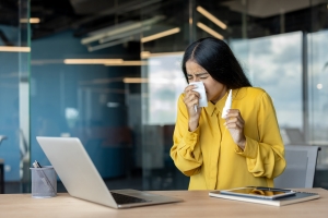 Female Employee Suffering from Cold at Office Desk
