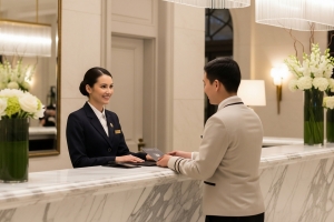 Hotel Receptionist Assisting A Guest at Marble Check-in Counter