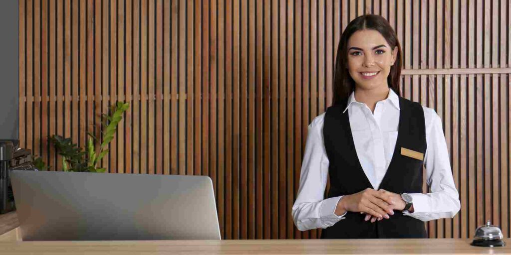 Smiling Female Concierge Standing at Her Desk