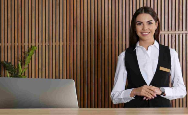 Smiling Female Concierge Standing at Her Desk