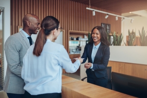 Smiling Concierge Interacting with Guests on Her Desk