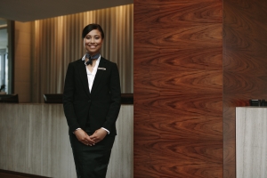 Smiling Female Concierge Standing Near Her Desk in an Apartment Building
